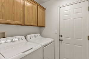 Washroom featuring washing machine and dryer and cabinet space