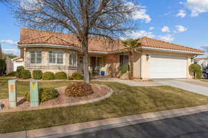 Mediterranean / spanish-style home with stucco siding, driveway, a tile roof, and an attached garage