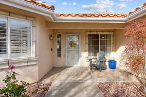 View of exterior entry with stucco siding and a tiled roof