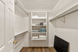 Walk in closet with light wood-style floors