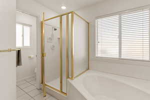 Full bath with a stall shower, a bath, and light tile patterned floors