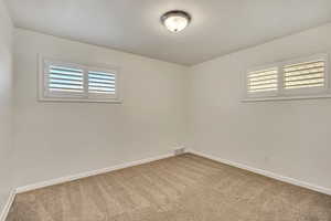 Unfurnished room featuring light colored carpet and plenty of natural light