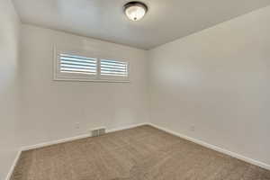 Spare room with baseboards and carpet flooring