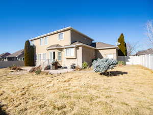 Rear view of house featuring a fenced backyard, a patio area, and stucco siding