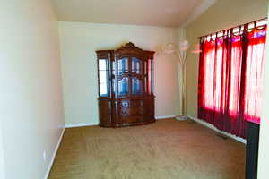 Carpeted empty room featuring baseboards