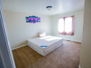 Carpeted bedroom featuring baseboards