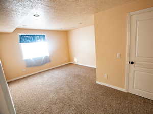 Carpeted spare room featuring a textured ceiling and recessed lighting