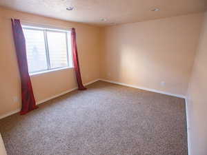 Carpeted spare room featuring baseboards and recessed lighting