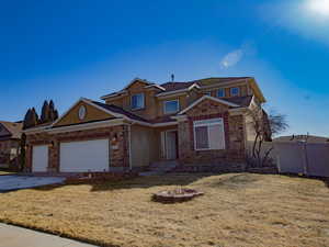Traditional home featuring stucco siding, an attached garage, a gate, and concrete driveway
