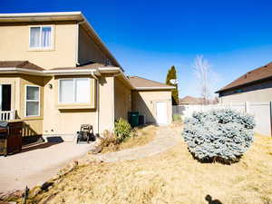 View of side of home with stucco siding, a patio area, and roof with shingles