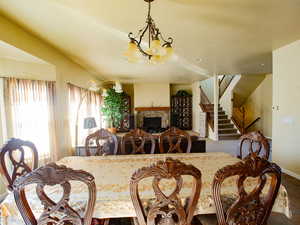 Dining space with a stone fireplace and suspended lighting