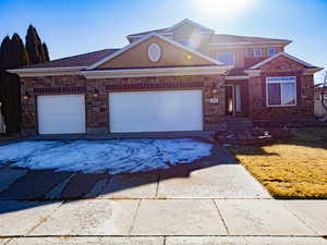 View of front facade with concrete driveway, an attached garage, stucco siding, and a front yard