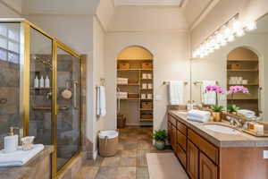 Bathroom featuring double vanity, a shower stall, and built in features