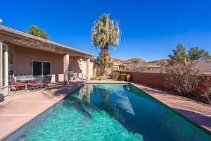 View of swimming pool featuring a fenced backyard, patio surround, outdoor dining area, and a mountain view