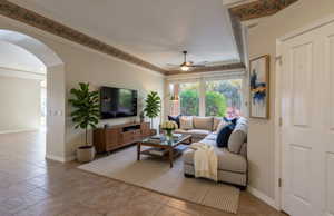 Virtually Staged Living area featuring arched walkways, a ceiling fan, and light tile patterned flooring
