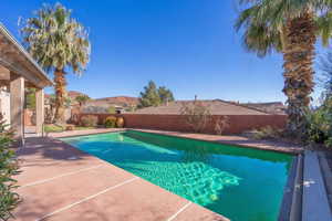 View of swimming pool with patio surround and a fenced backyard