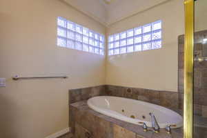 Full bath with a jetted tub and plenty of natural light