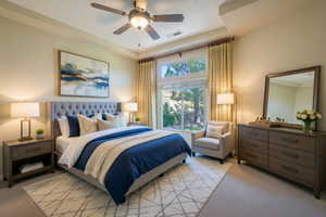 Bedroom with light colored carpet, a tray ceiling, and a ceiling fan