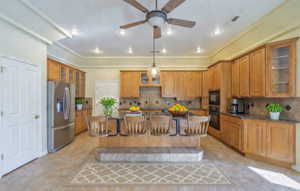Virtually Staged Kitchen featuring glass insert cabinets, a kitchen island, black appliances, wood finish cabinetry, and crown molding