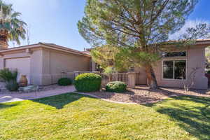 View of front facade featuring stucco siding, a front yard, and an attached garage