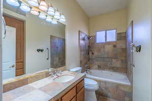 Bathroom featuring tiled shower / bath and vanity