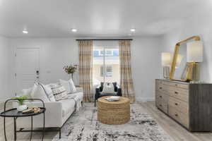 Living area with light wood-type flooring, recessed lighting, and a textured ceiling