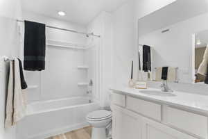 Bathroom with vanity, tub / shower combination, and light wood finished floors
