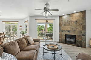 Living area featuring wood finished floors, a tile fireplace, recessed lighting, and a ceiling fan