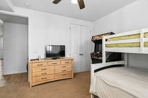 Bedroom featuring a closet, a ceiling fan, and light colored carpet