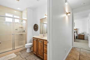 Bathroom with a shower stall, vanity, and light tile patterned floors