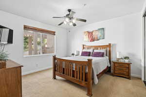 Bedroom featuring light colored carpet and a ceiling fan