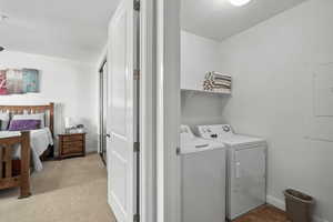 Laundry area featuring electric panel and washing machine and clothes dryer