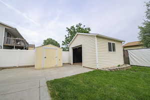 View of shed with a fenced backyard and driveway