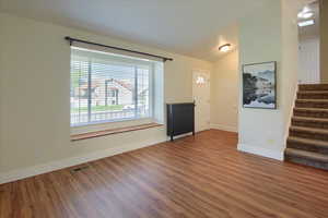 Entryway with vaulted ceiling and wood finished floors