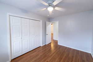 Unfurnished bedroom featuring wood finished floors, ceiling fan, and a closet