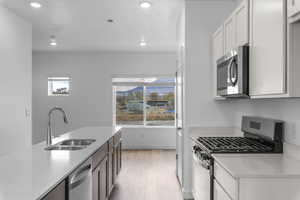 Kitchen featuring stainless steel appliances, light stone counters, recessed lighting, and light wood-style floors