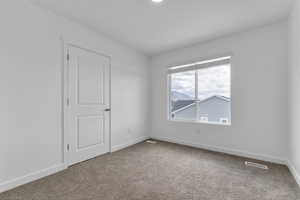 Carpeted spare room with baseboards