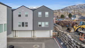 View of property exterior with board and batten siding, an attached garage, brick siding, and a mountain view
