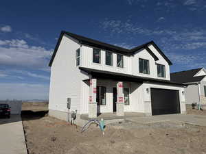 View of front of home featuring a porch, an attached garage, and concrete driveway