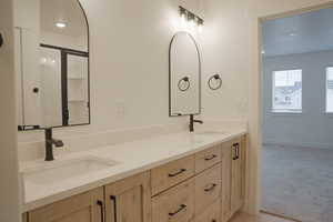 Full bathroom featuring double vanity, recessed lighting, light carpet, and a stall shower