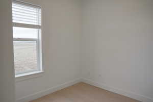 Spare room featuring baseboards and light wood-style flooring