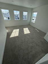 Spare room featuring baseboards and carpet flooring