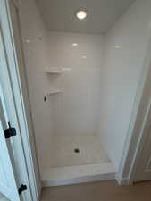 Full bath with a shower stall and crown molding
