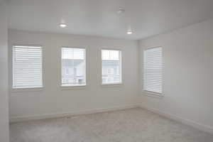 Unfurnished room featuring light colored carpet and baseboards