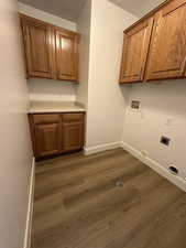 Laundry room featuring cabinet space, hookup for a washing machine, dark wood-style flooring, hookup for an electric dryer, and a textured ceiling