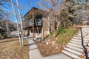 View of front facade with a balcony and a front yard