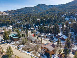 Snowy aerial view featuring a mountain view and a residential view