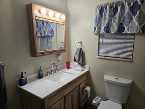 Half bathroom featuring a textured wall and vanity