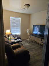 Living area with dark wood-style floors and baseboards