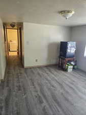 Interior space with a textured ceiling, dark wood-style flooring, and washer / dryer